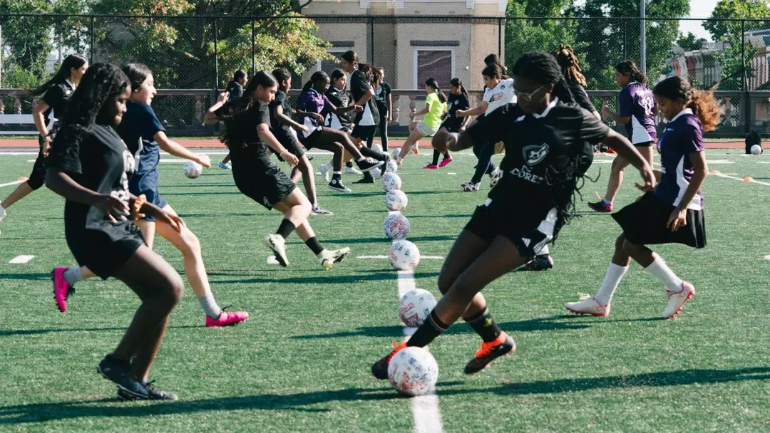 Young girls participate in soccer drills with DC SCORES