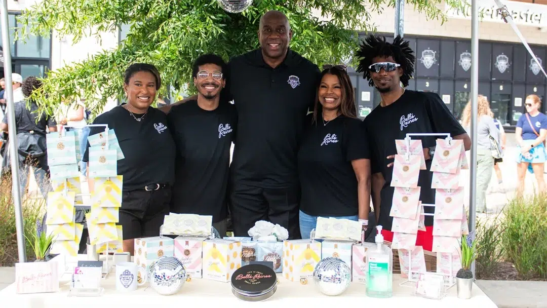 Magic Johnson with a owners of Shop Our Spirit business.