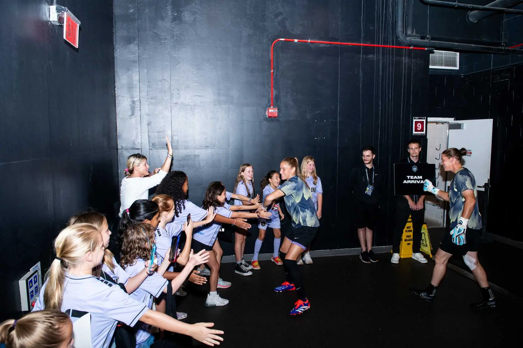 Players high-fiving kids